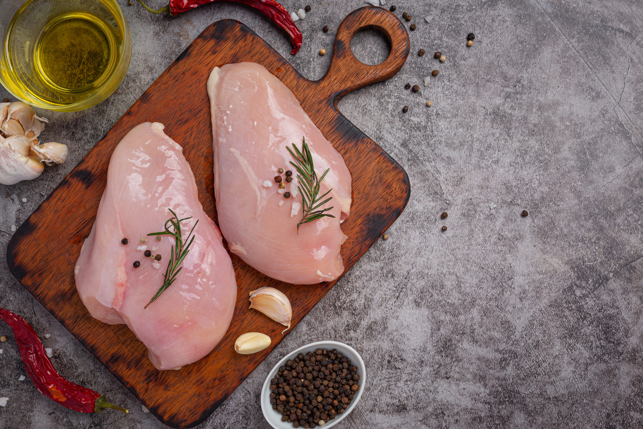 Raw chicken breast on the dark background.